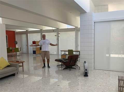 A man standing with his arms open in a modern living space