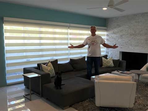 A man standing with his arms open in a modern living room